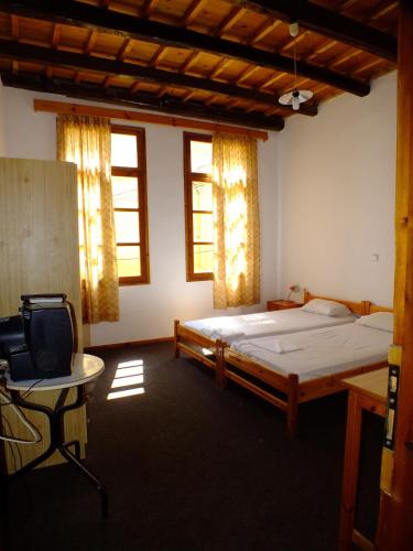 a bedroom with a bed and a desk and a tv at Lito Rooms in Chania