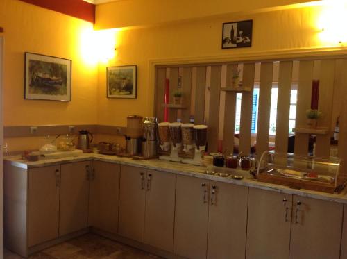a kitchen with white cabinets and a counter top at Hotel Nostos in Frikes
