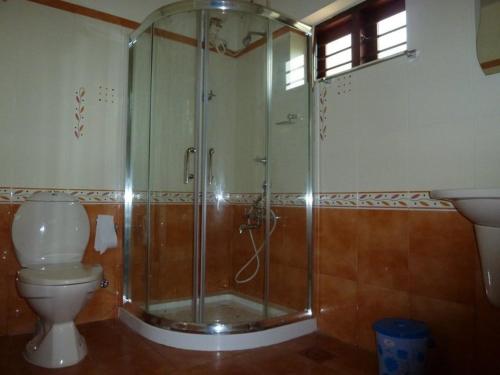 a bathroom with a shower and a toilet and a sink at Rajadhani 5th Season in Varkala