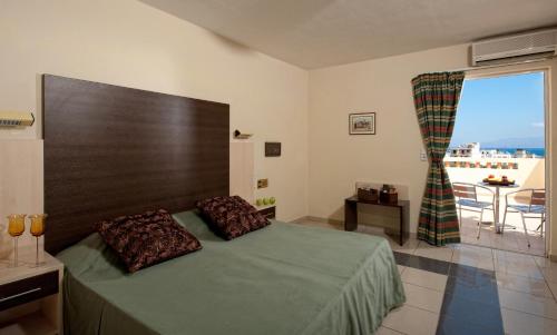 a bedroom with a bed and a large window at Senses Blue Boutique hotel in Hersonissos