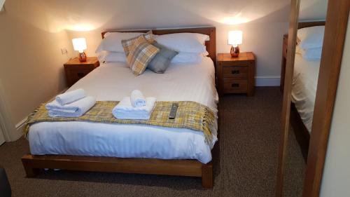 um quarto com uma cama com toalhas em The Barn Courtyard em Shepshed