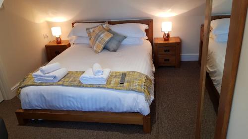 een slaapkamer met een bed met handdoeken erop bij The Barn Courtyard in Shepshed