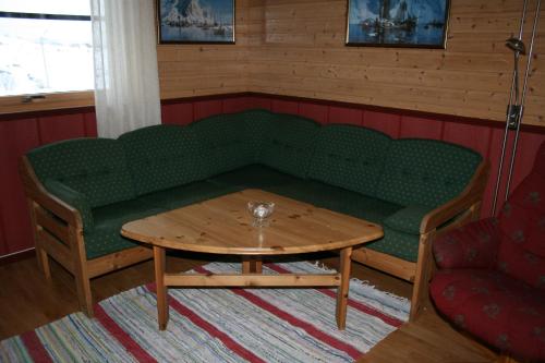 a green couch and a table in a room at Offersøy Feriesenter in Offersøy