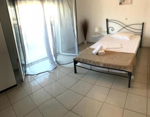 a bedroom with a bed and a large window at Elenas Apartments in Plataria