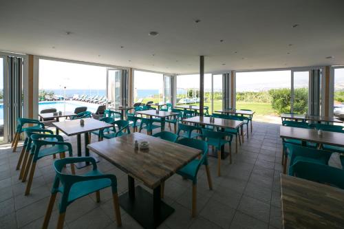 a restaurant with tables and chairs and windows at Marica's Boutique Hotel in Paphos