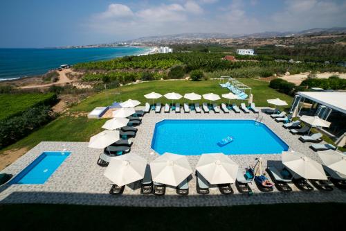 uma vista aérea para uma piscina com cadeiras e guarda-sóis em Marica's Boutique Hotel em Pafos