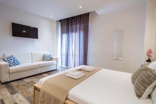 a bedroom with a large bed and a couch at Politeama Luxury Suites in Palermo