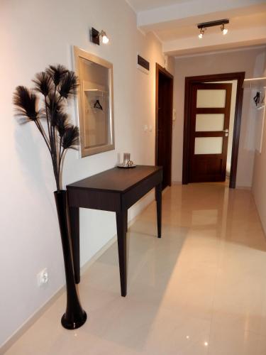 a black table in a room with a vase with flowers at Apartamenty "Kotlina" in Bystrzyca Kłodzka