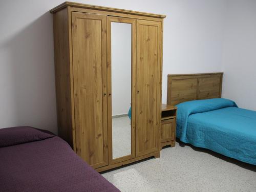 a bedroom with two beds and a large mirror at Pozo Izquierdo Homelidays in Pozo Izquierdo