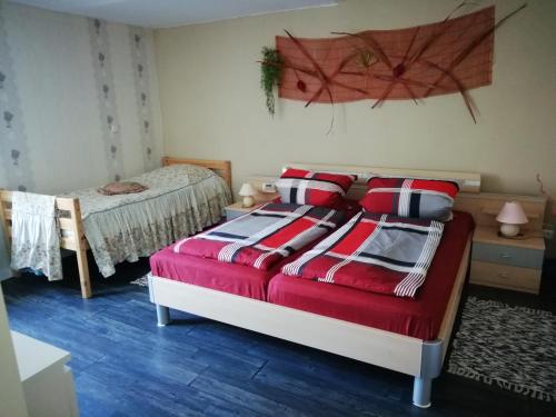 a bedroom with a bed with a red comforter at Ferienwohnung Zur Alten Schule in Pritzwalk