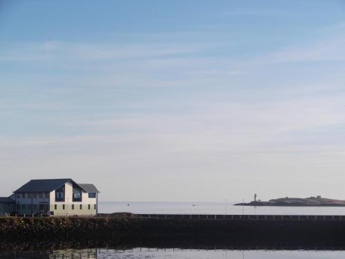 a house on the shore of a body of water at Twenty Seven in Stornoway