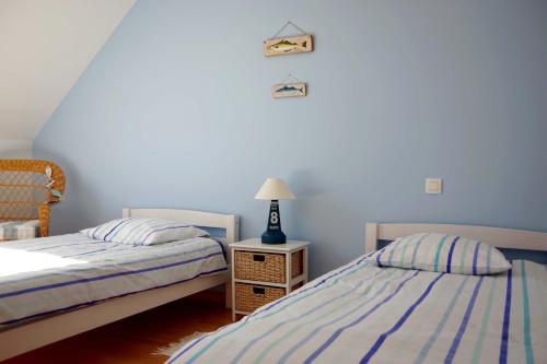 プルゲルノーにあるMaison "Ouessant" Pays des Abersのベッドルーム1室(ベッド2台、ナイトスタンドのランプ付)