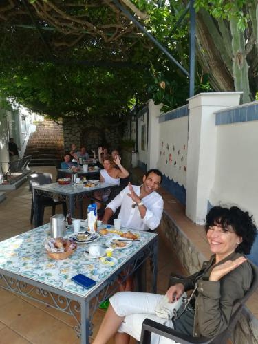 a group of people sitting at a table eating food at Hotel 4 Stagioni in Capri