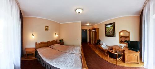 Dormitorio con cama, escritorio y TV en Pension Curmatura Stezii, en Răşinari