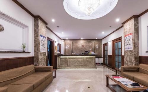 a lobby with couches and a desk in a building at Hotel Godwin - Colaba in Mumbai