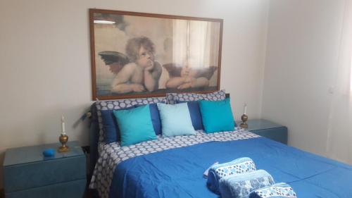 a bedroom with a blue bed with a painting on the wall at Via Borghetto di Vara 13 in Rome