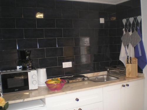a kitchen counter with a sink and a microwave at A Tasca in Vila Real