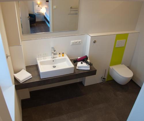 La salle de bains est pourvue d'un lavabo et de toilettes. dans l'établissement Hof Hahnenberg, à Wagenfeld