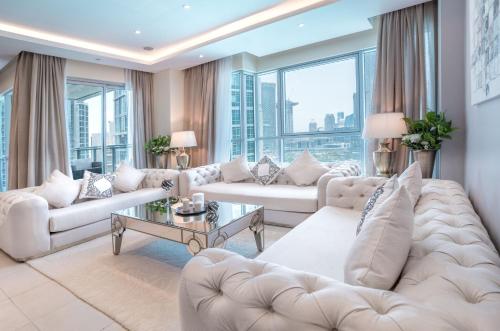 a living room with white furniture and large windows at Elite Royal Apartment - Burj Residences Tower 5 in Dubai