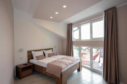 a bedroom with a bed and a large window at Villa Aba apartments in Sarajevo