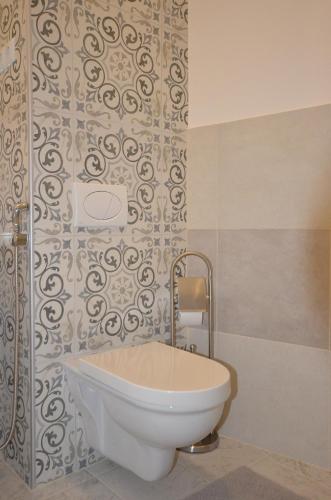 a white tub in a bathroom with a wall at Villa Aba apartments in Sarajevo