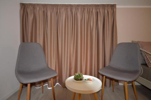 two chairs and a table in front of a window at Villa Aba apartments in Sarajevo
