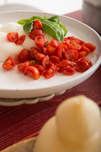 a plate of tomatoes and lettuce on a table at Masseria San Giovanni - Epoca Collection in Fasano