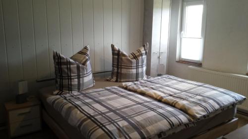 a bedroom with a bed with pillows and a window at Ferienhaus Storchenweg in Mahlzow