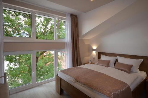 a bedroom with a large bed and large windows at Villa Aba apartments in Sarajevo