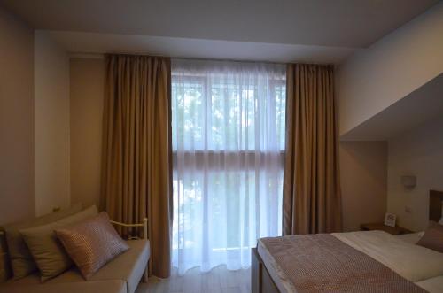 a bedroom with a bed and a large window at Villa Aba apartments in Sarajevo