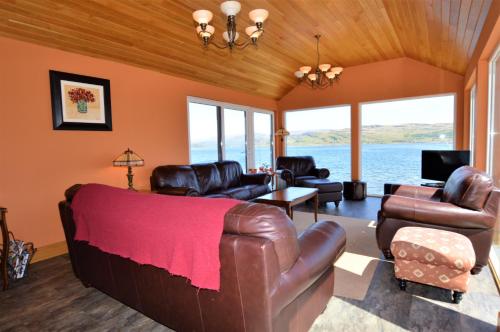 a living room with a leather couch and chairs at Taigh na Mara in Kames