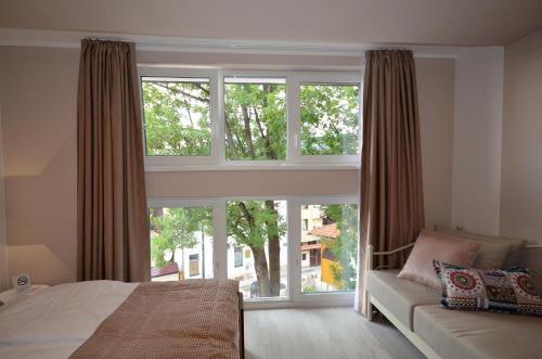 a bedroom with a bed and a large window at Villa Aba apartments in Sarajevo