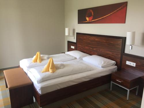 a bedroom with a bed with two yellow pillows on it at Hotel Liebmann in Lassnitzhöhe