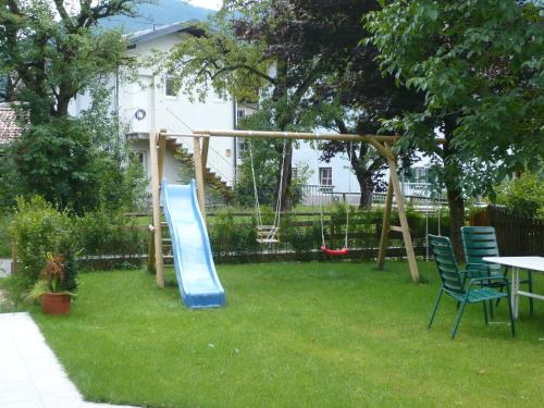 a playground with a blue slide in a yard at Pension Wörndl in Fuschl am See