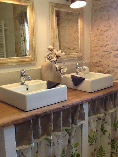 une salle de bain avec deux lavabos et un miroir dans l'établissement Le Champêtre, à Bazoges-en-Pareds