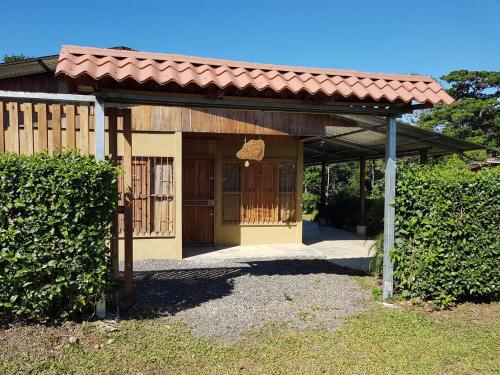 a small building with a roof and a gate at Casa para vacacionar Family in Chachagua