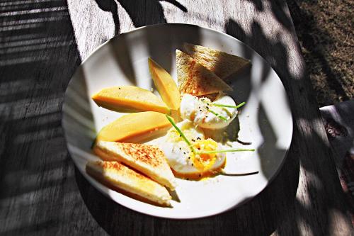 un piatto di cibo con pane e frutta su un tavolo di Meno Dream Resort a Gili Meno