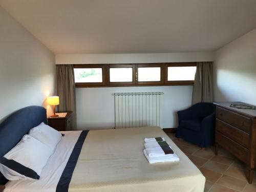 1 dormitorio con 1 cama y 1 silla azul en La Poderina Appartamenti, en Castelnuovo dellʼAbate