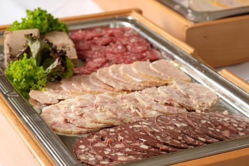 a tray of meat and other food on a table at Hotel Restaurant Clemens-August in Ascheberg