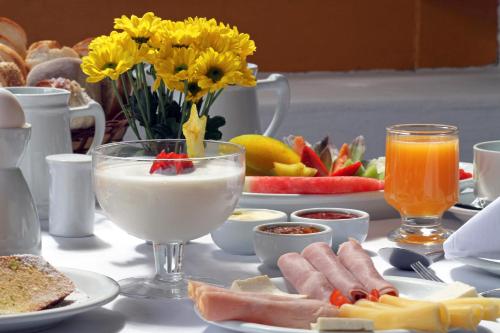 a table with breakfast foods and drinks on it at Pousada do Ouro in Paraty