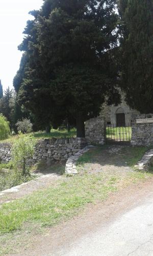 a stone wall with a tree and a fence at Agriturismo Nonni Devia in Lucinasco