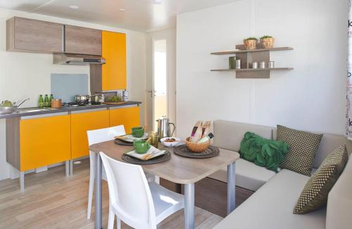 a kitchen with a table and chairs and a dining room at camping Le Médiéval in Turckheim