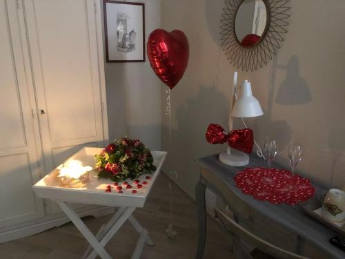a room with a table with a heart balloon and a heart balloon at Dal Patriarca in Imperia