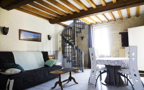 un salon avec un canapé noir et une table dans l'établissement FamilyGites, à Meuvaines