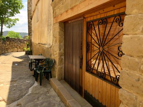 a wooden door with a table and chairs next to a building at Solano de Moran in Murillo de Gállego