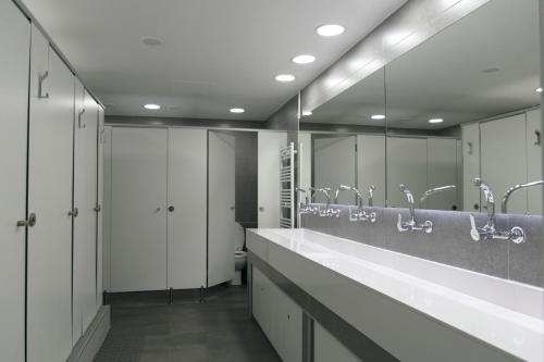 a bathroom with two sinks and mirrors and a toilet at Alberguinn in Barcelona