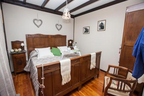San Damiano dʼAstiにあるCugi Bed and Breakfastのベッドルーム(木製ベッド1台、椅子付)