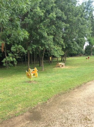 a park with a playground with a yellow toy in the grass at Le President-Gare Nimes Pont Du Gard in Bellegarde