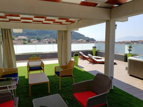 a patio with chairs and a lawn with a view at Apartments Villa Katija in Drvenik