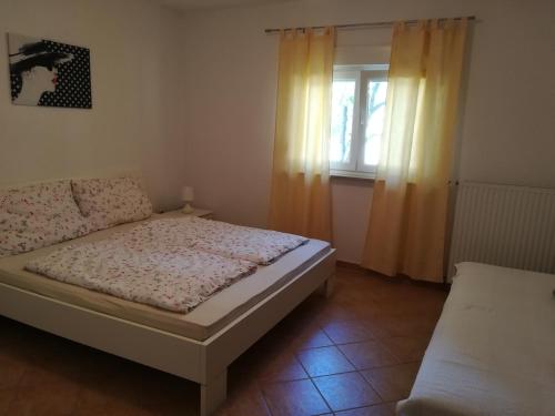 a small bedroom with a bed and a window at Apartment Tanja in Vrsar